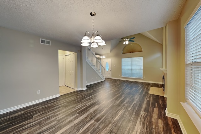 unfurnished living room with dark wood-type flooring, lofted ceiling, a textured ceiling, and a wealth of natural light