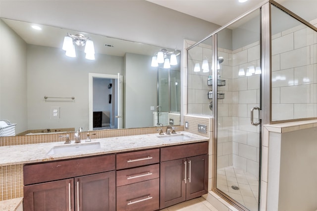 bathroom featuring tasteful backsplash, tile patterned flooring, vanity, and a shower with shower door