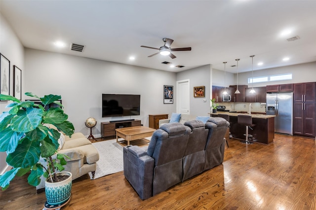 living room featuring dark hardwood / wood-style floors, ceiling fan, and sink