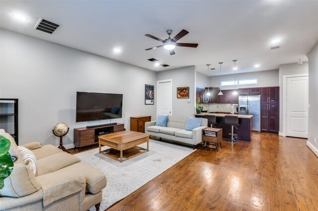 living room with ceiling fan and dark hardwood / wood-style flooring