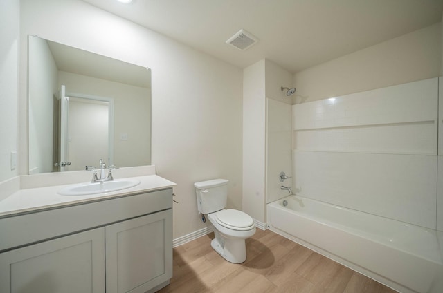 full bathroom with wood-type flooring, toilet, vanity, and tiled shower / bath