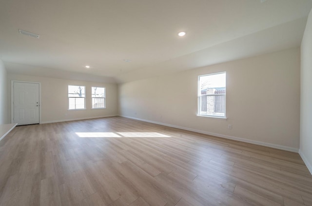 unfurnished room with a healthy amount of sunlight and light hardwood / wood-style flooring