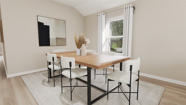 dining room featuring light wood-type flooring and vaulted ceiling