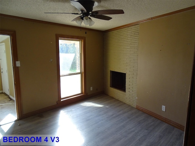 unfurnished living room featuring crown molding, ceiling fan, a textured ceiling, a fireplace, and wood-type flooring