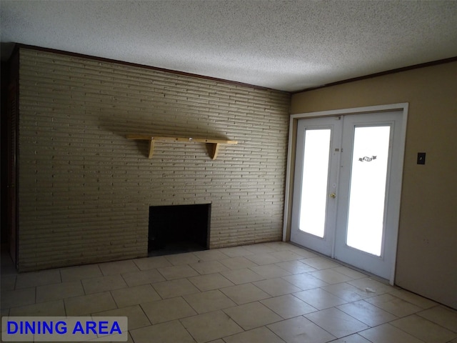 unfurnished living room featuring french doors, light tile patterned floors, a fireplace, a textured ceiling, and brick wall