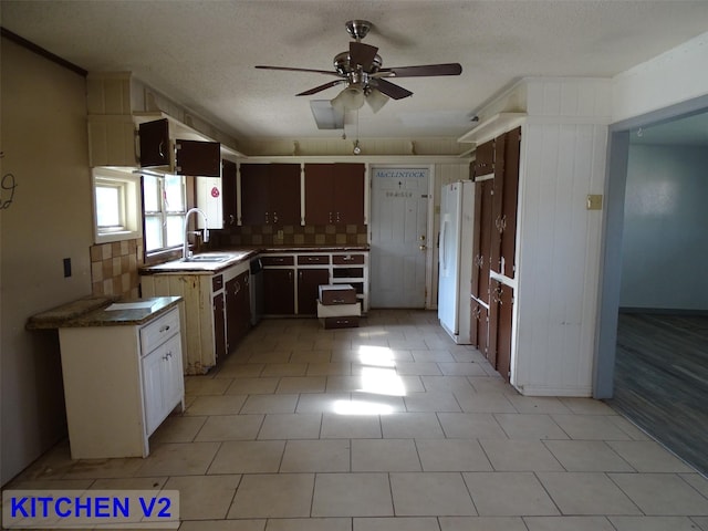 kitchen with tasteful backsplash, a textured ceiling, ceiling fan, sink, and white fridge