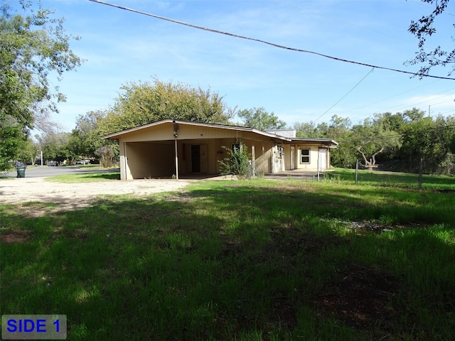 rear view of property featuring a carport and a lawn