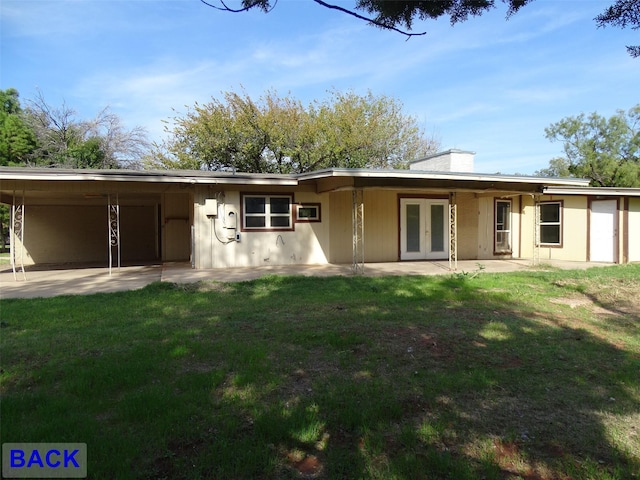 rear view of property featuring french doors and a lawn