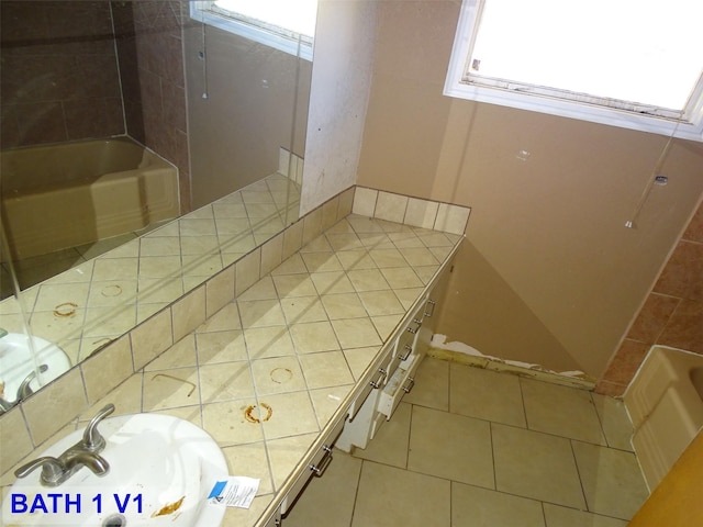 interior space featuring tile patterned flooring, vanity, and a tub