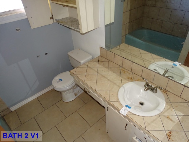 bathroom featuring a bathing tub, tile patterned flooring, vanity, and toilet