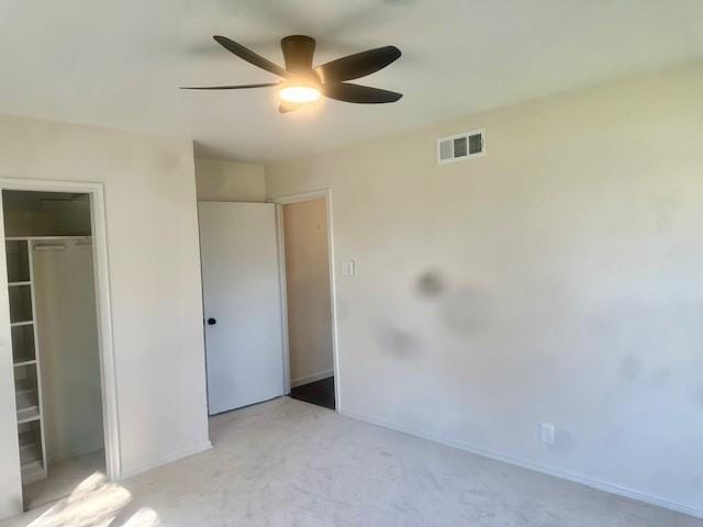 unfurnished bedroom featuring ceiling fan, a closet, and light colored carpet