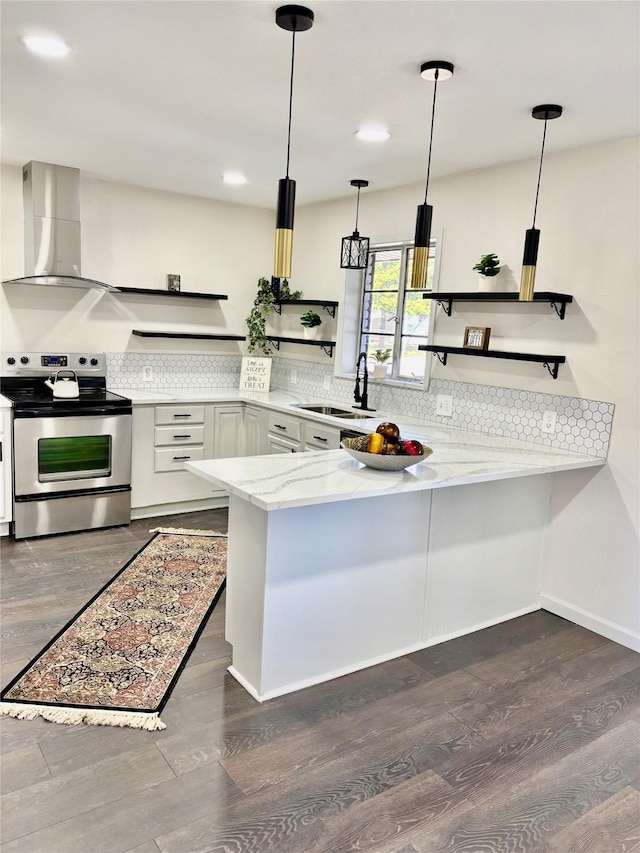 kitchen with electric range, pendant lighting, wall chimney range hood, and kitchen peninsula