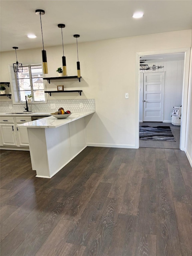 kitchen featuring white cabinets, pendant lighting, dark hardwood / wood-style flooring, and kitchen peninsula