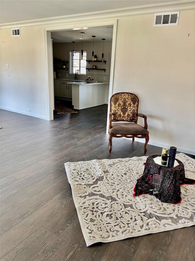 sitting room featuring crown molding and dark wood-type flooring