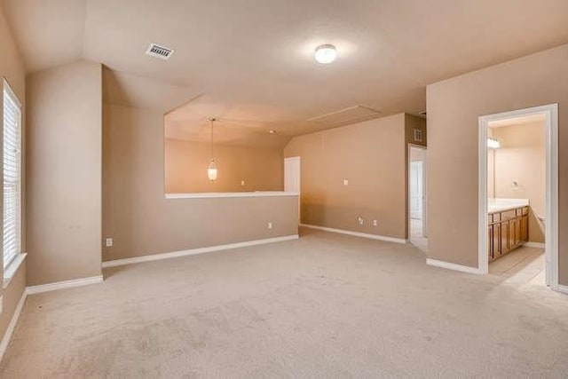 carpeted empty room with a wealth of natural light and vaulted ceiling