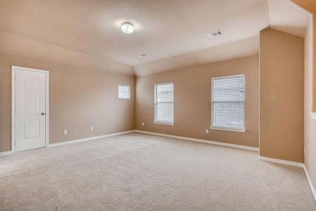 unfurnished room with lofted ceiling and light carpet