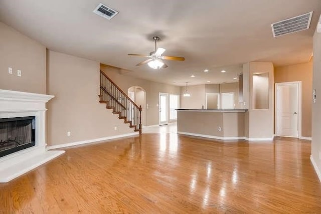 unfurnished living room featuring ceiling fan and light hardwood / wood-style flooring