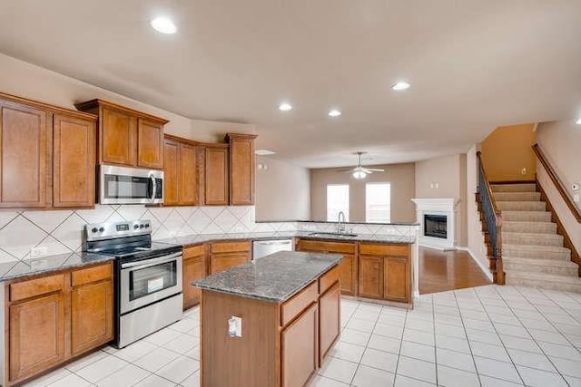 kitchen featuring a center island, sink, light tile patterned floors, and stainless steel appliances