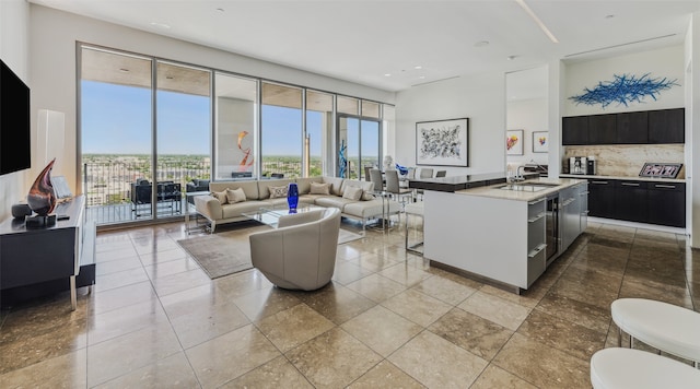 kitchen with tasteful backsplash, a center island with sink, and sink