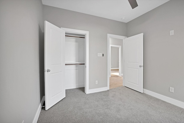 unfurnished bedroom featuring light colored carpet, a closet, and ceiling fan