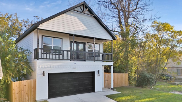 view of front of property featuring a balcony, a garage, and a front lawn