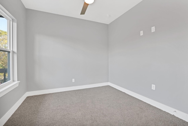 carpeted spare room featuring ceiling fan and a healthy amount of sunlight