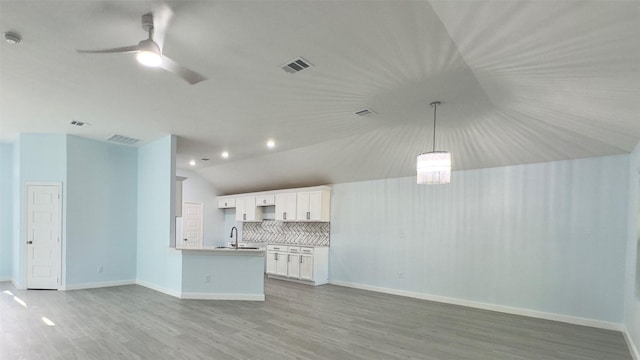 unfurnished living room featuring sink, ceiling fan, light hardwood / wood-style floors, and lofted ceiling