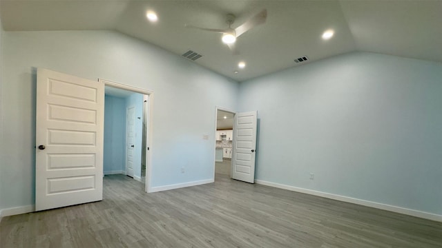 unfurnished room with light hardwood / wood-style floors and lofted ceiling