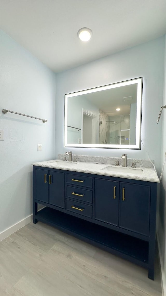 bathroom with hardwood / wood-style floors, an enclosed shower, and vanity