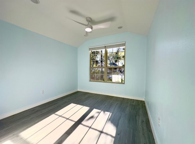 spare room with dark wood-type flooring, vaulted ceiling, and ceiling fan