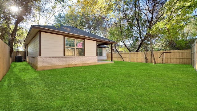 rear view of property with cooling unit and a yard