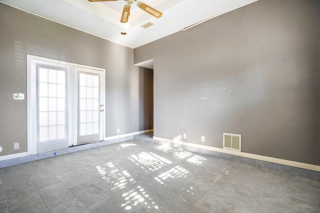 empty room with a tray ceiling and ceiling fan