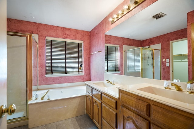 bathroom with vanity and shower with separate bathtub