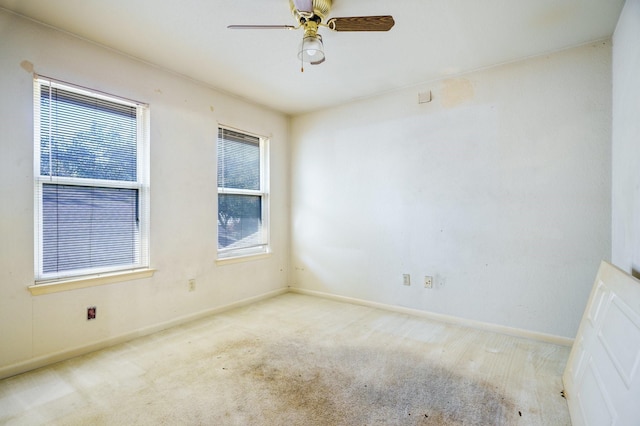 carpeted spare room with ceiling fan