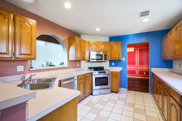 kitchen featuring appliances with stainless steel finishes, light tile patterned floors, and sink