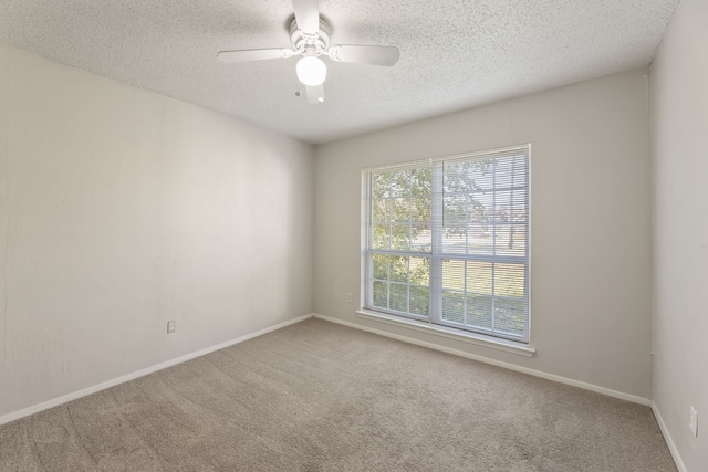 spare room with carpet flooring, a textured ceiling, and ceiling fan