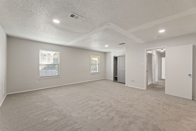 carpeted empty room with a textured ceiling