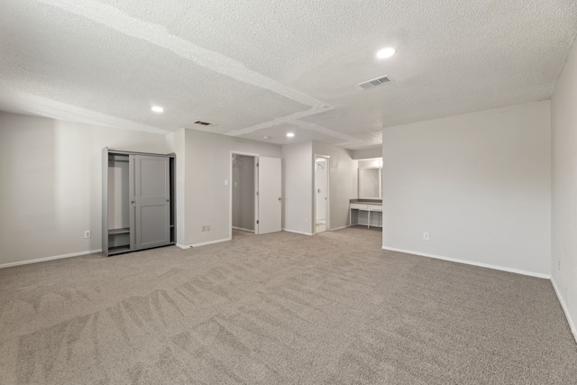 carpeted spare room with a textured ceiling