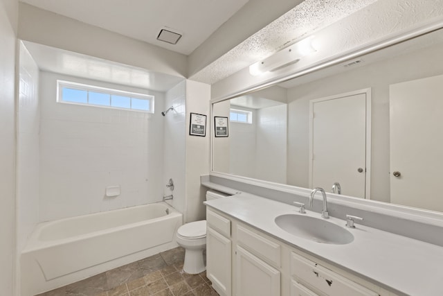 full bathroom featuring vanity, tiled shower / bath combo, toilet, and a wealth of natural light