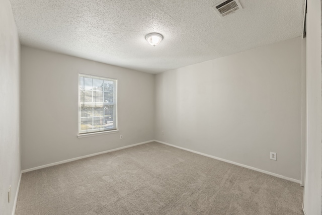 carpeted empty room with a textured ceiling