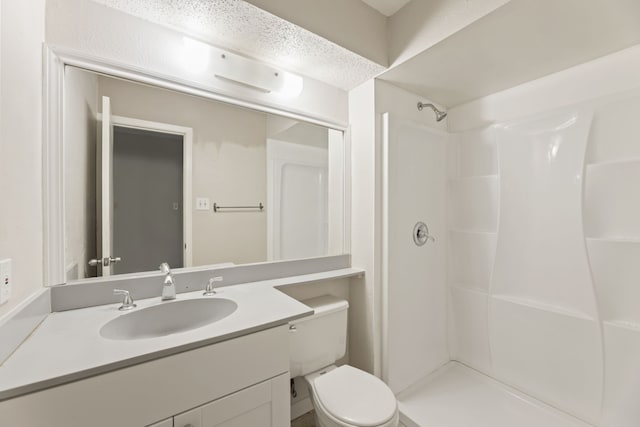 bathroom with vanity, toilet, and a shower