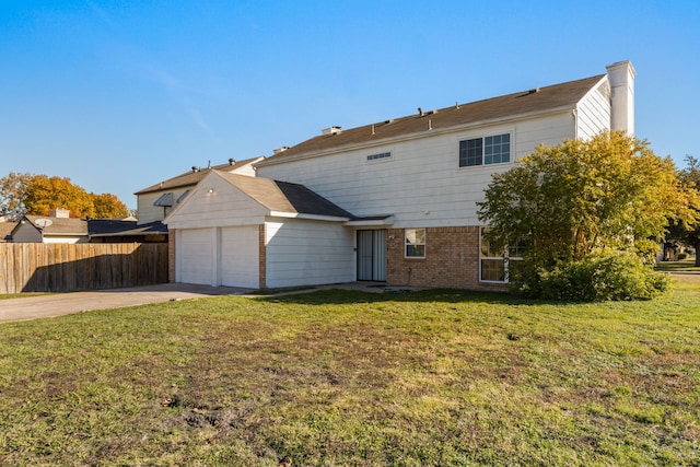 back of house with a lawn and a garage