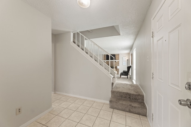 staircase featuring tile patterned floors and a textured ceiling