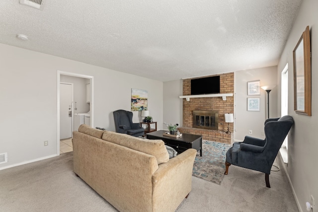 carpeted living room with washing machine and clothes dryer, a fireplace, and a textured ceiling