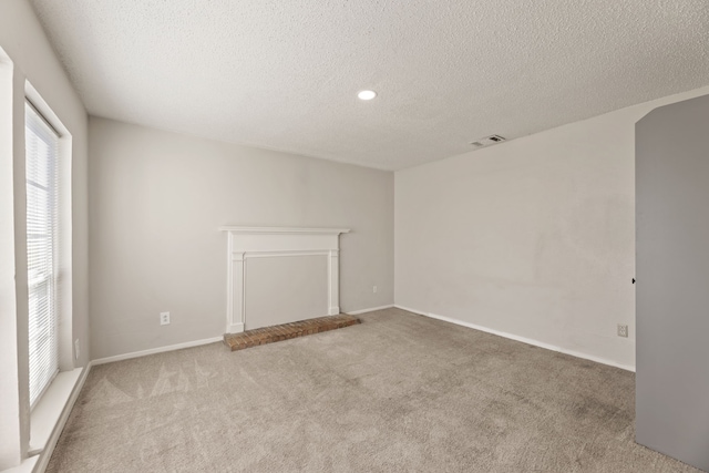 unfurnished living room with light carpet and a textured ceiling