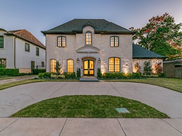 french provincial home featuring a yard and french doors