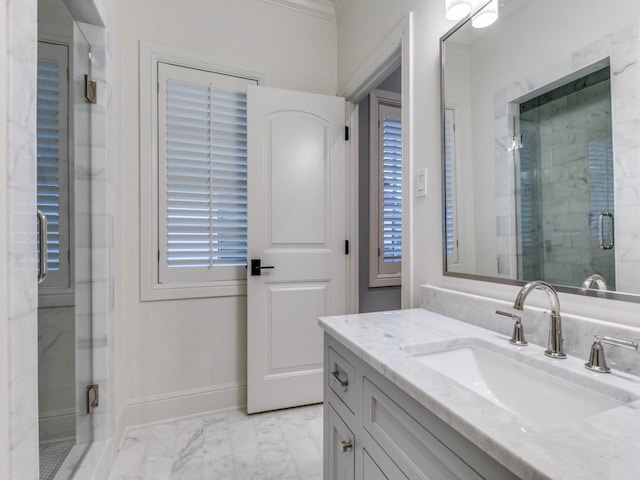 bathroom with vanity, a shower with door, and crown molding