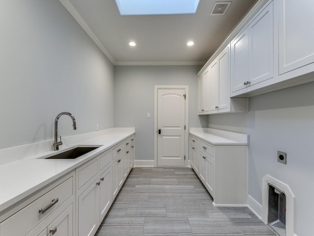 laundry room with electric dryer hookup, ornamental molding, sink, and a skylight