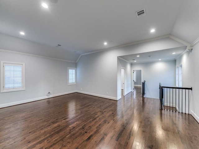 spare room featuring plenty of natural light, crown molding, dark wood-type flooring, and vaulted ceiling