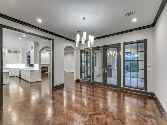 unfurnished room featuring plenty of natural light, a notable chandelier, and ornamental molding